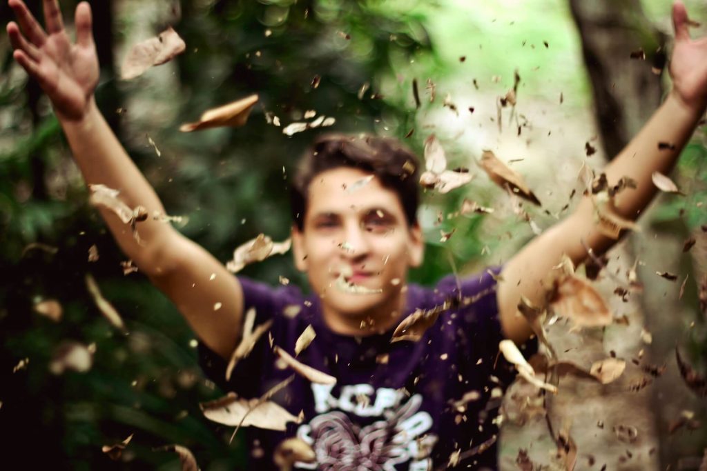 man playing with leaves