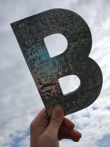 A hand holding the letter B